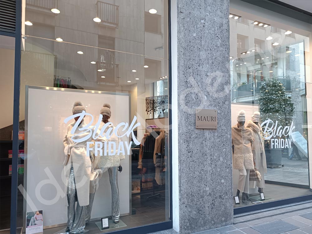 Scritte promozionali saldi stagionali su vetrina negozio