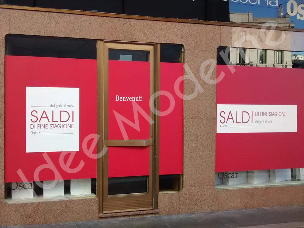Scritte promozionali saldi stagionali su vetrina negozio