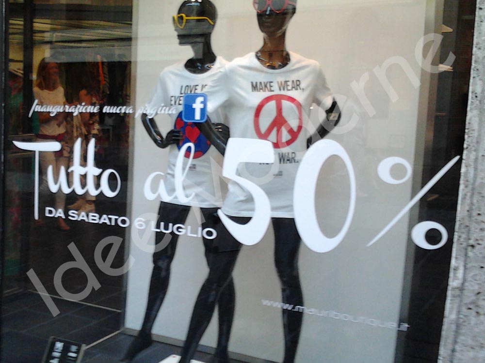 Scritte promozionali saldi stagionali su vetrina negozio