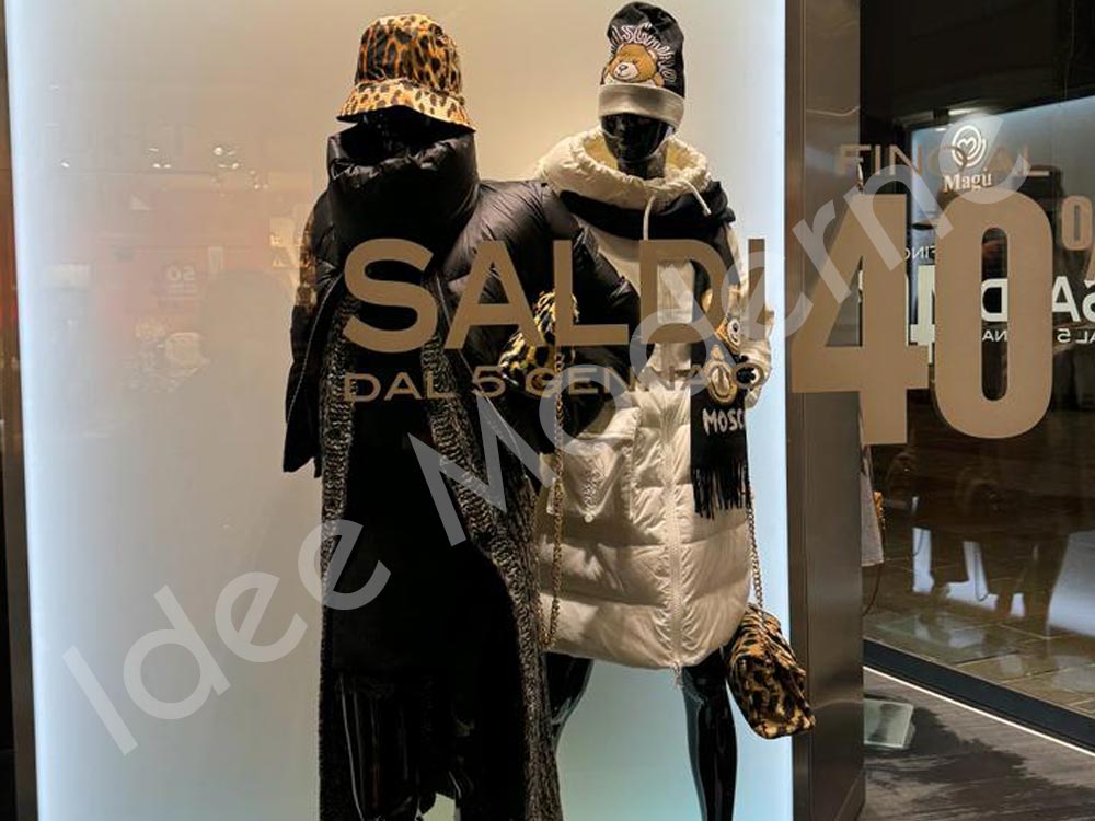 Applicazione scritte saldi e offerte su vetrina negozio